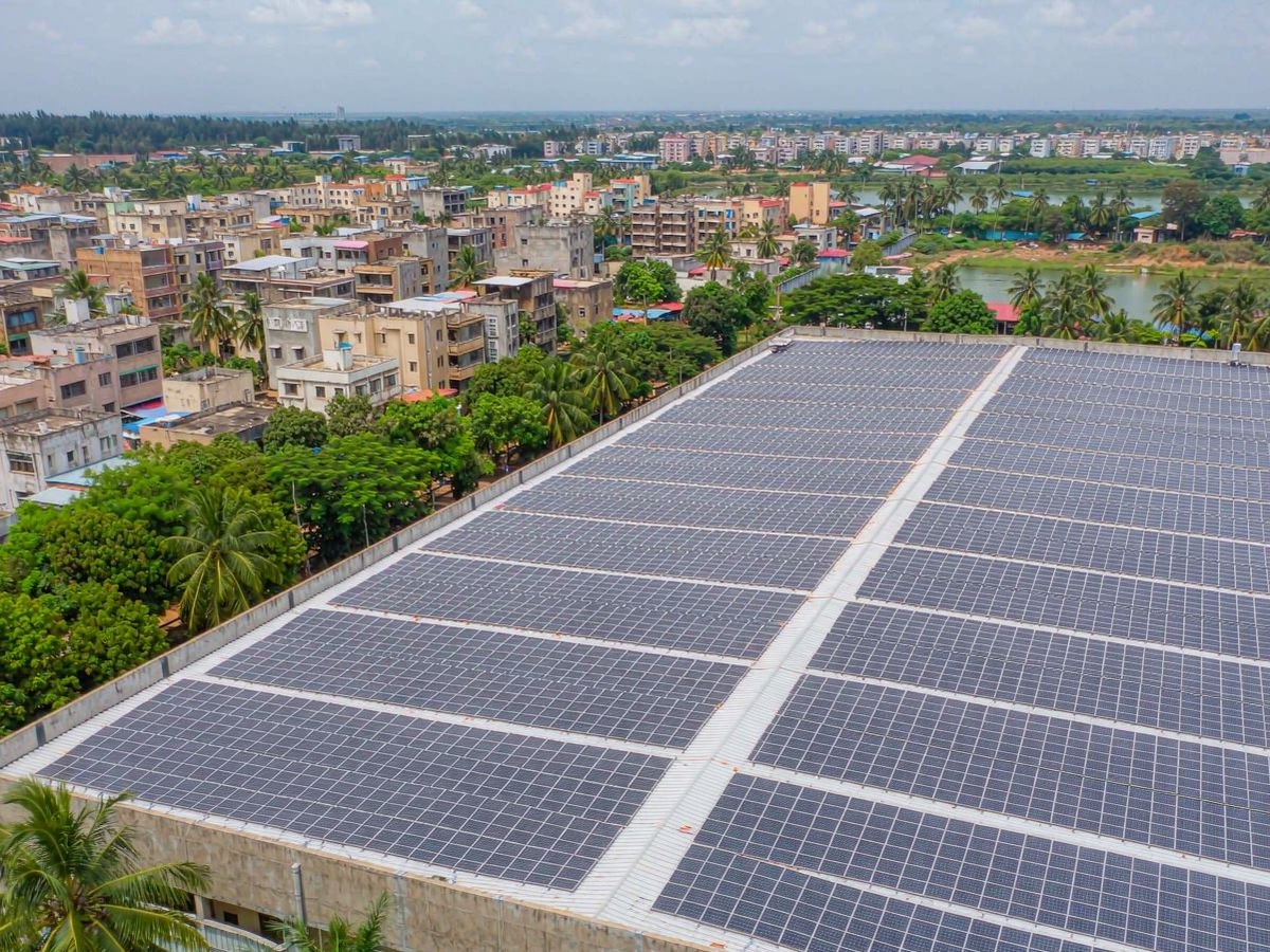 Aerial view of a completed 100kW commercial rooftop solar system on a warehouse in tropical West Africa — a top-end example of solar system cost in Ghana