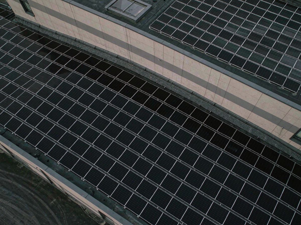 Aerial drone view of a large warehouse rooftop solar array layout