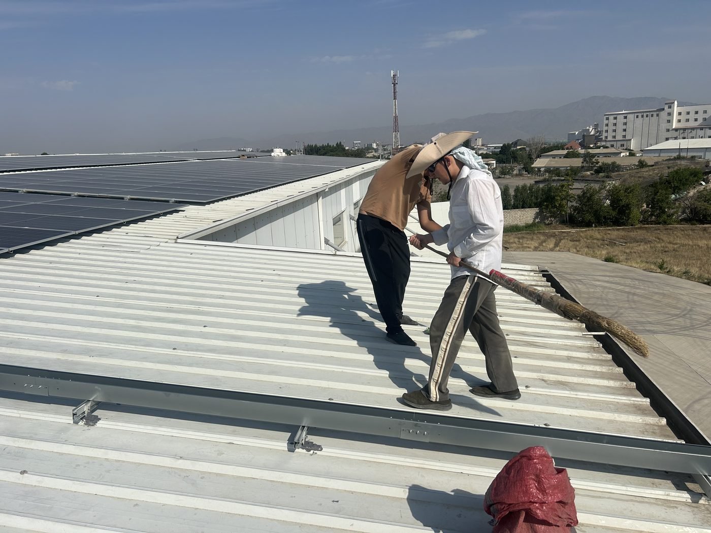 Technicians installing modules on the roof of a solar system for factory